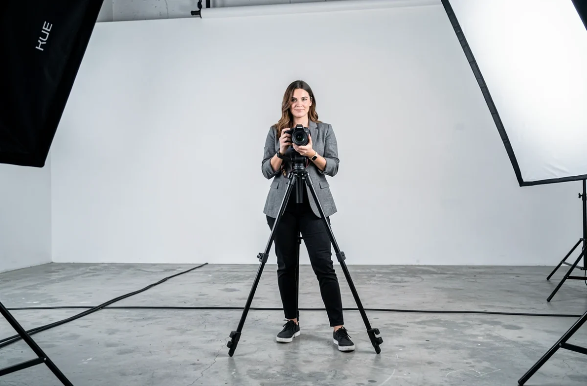 Photographe professionnelle en studio commercial avec trépied et équipement photo, illustrant les critères de tarification